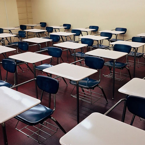 sala de aula com cadeiras e mesas vazias